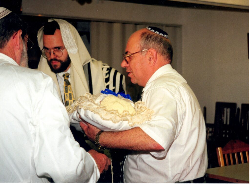 Father-in-Law handing Yitzchak Meir back to the Mohel