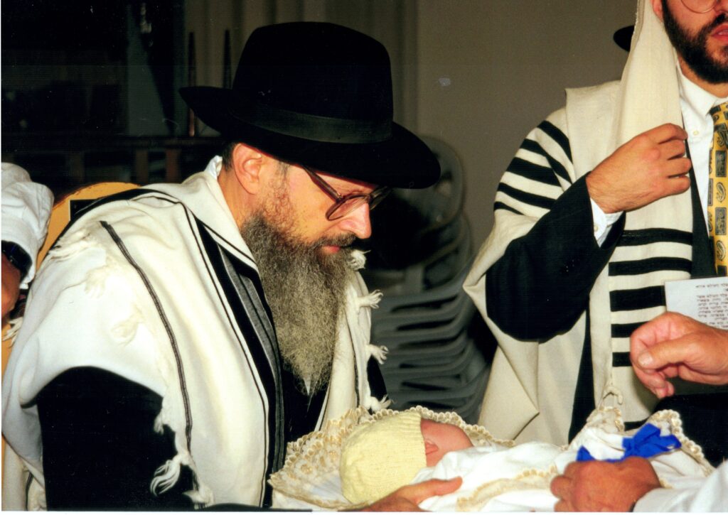 Rabbi Yitzchak Tratner, Sandek, holding Yitchak Meir